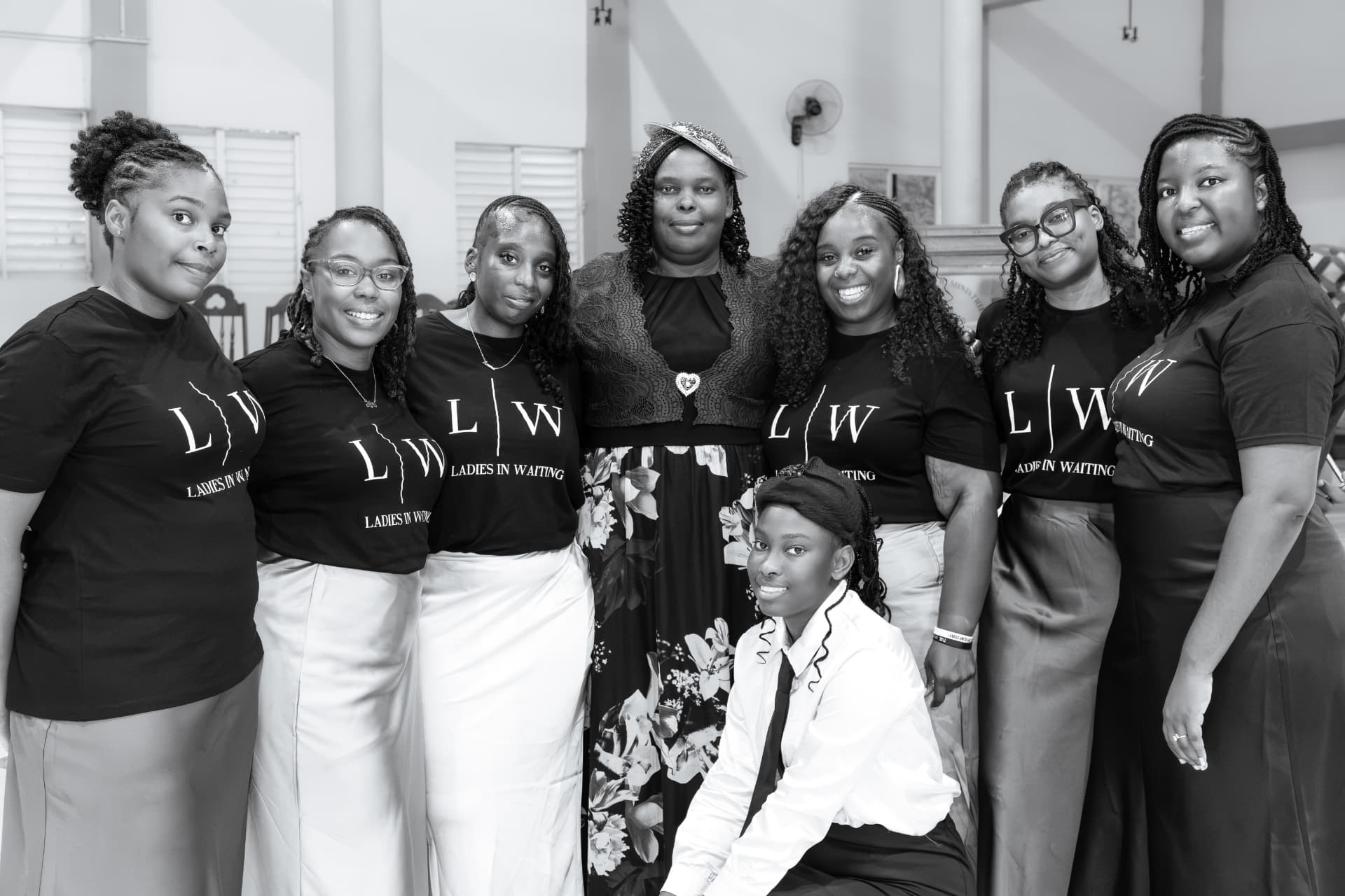 Black and white group portrait of the LIW Jamaica team with a guest at the launch