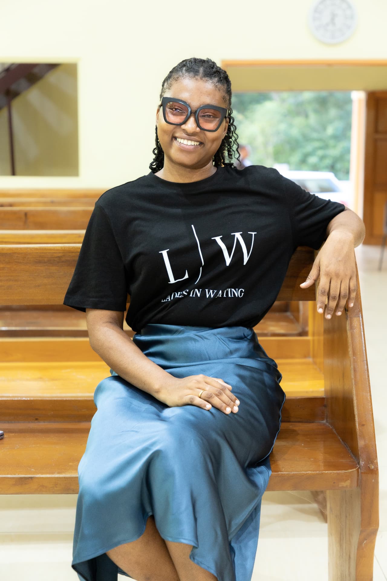 An LIW Jamaica team member relaxing on a pew in a branded T-shirt