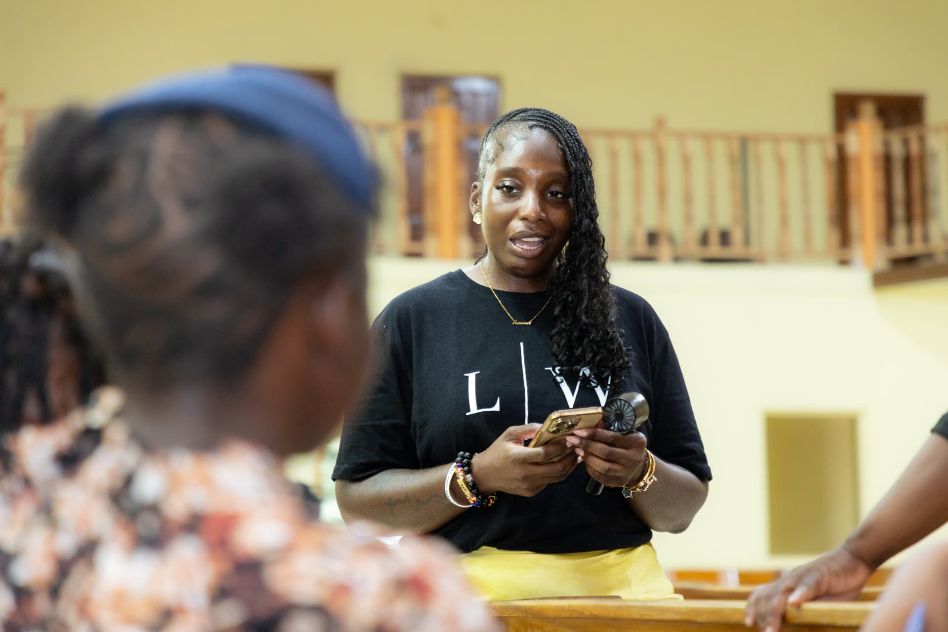 An LIW Jamaica team member in a branded T-shirt addressing the room