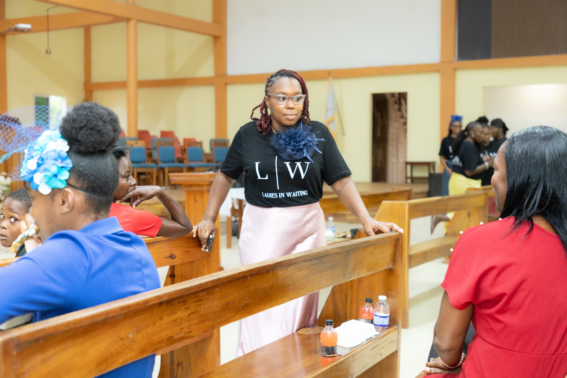 An LIW Jamaica lead standing among the pews engaging with attendees after the presentation
