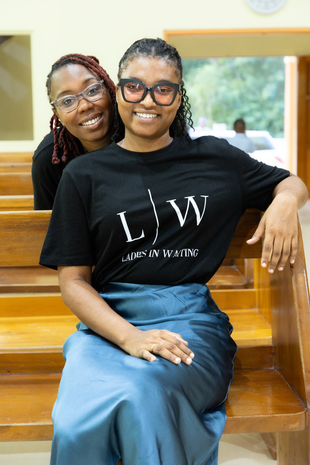 Two LIW Jamaica team members sitting together on a pew after the launch