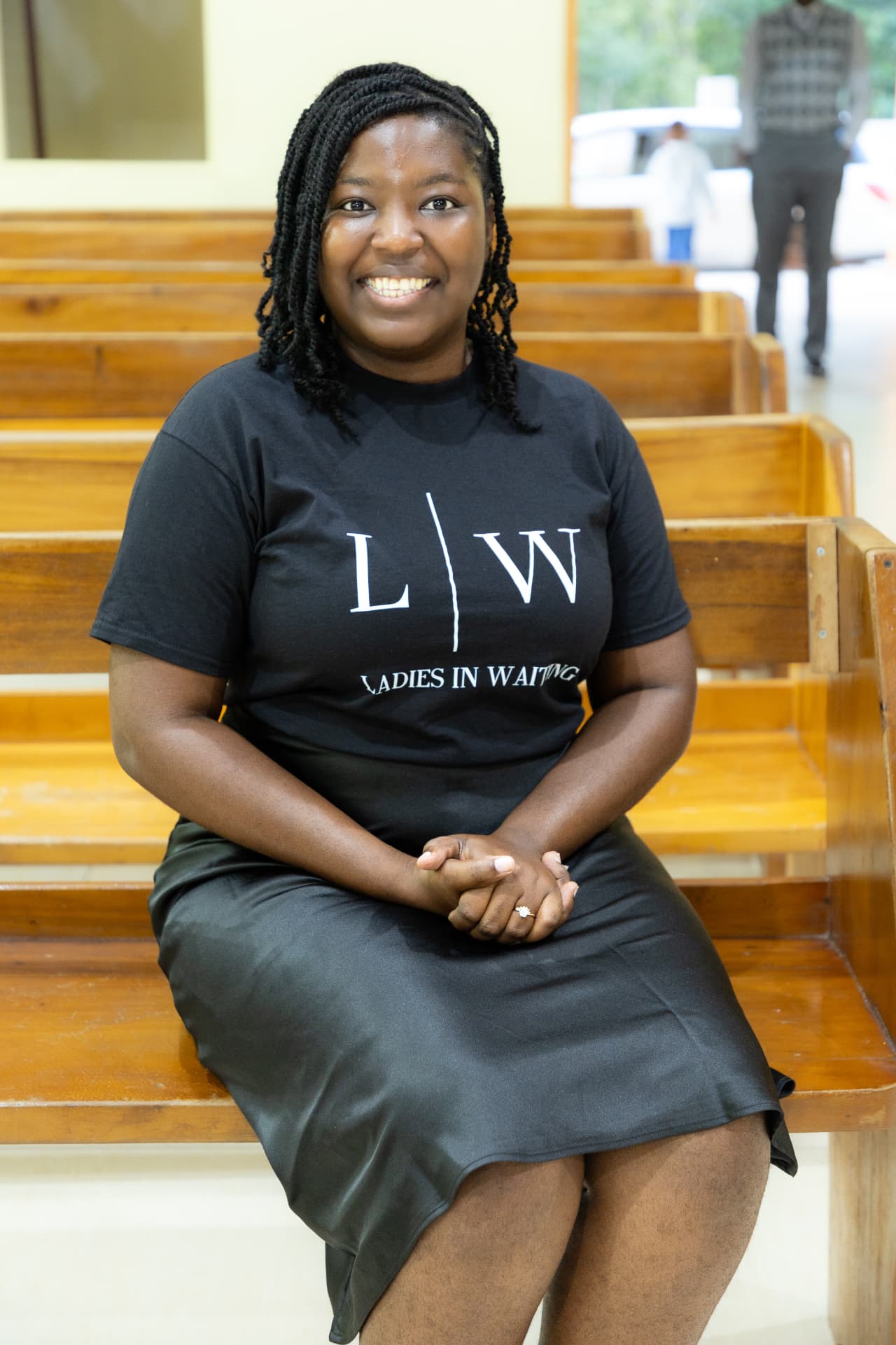 An LIW Jamaica volunteer smiling while seated on a pew at the launch venue